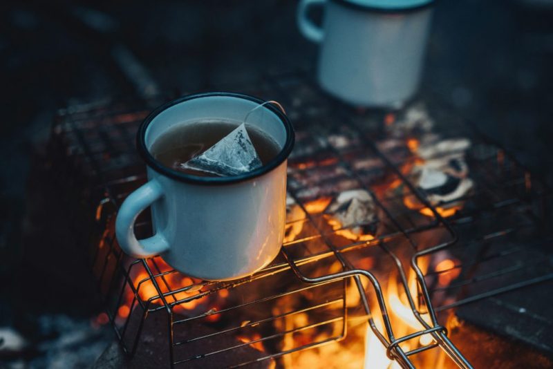 یک فنجان نوشیدنی داغ در کنار آتش