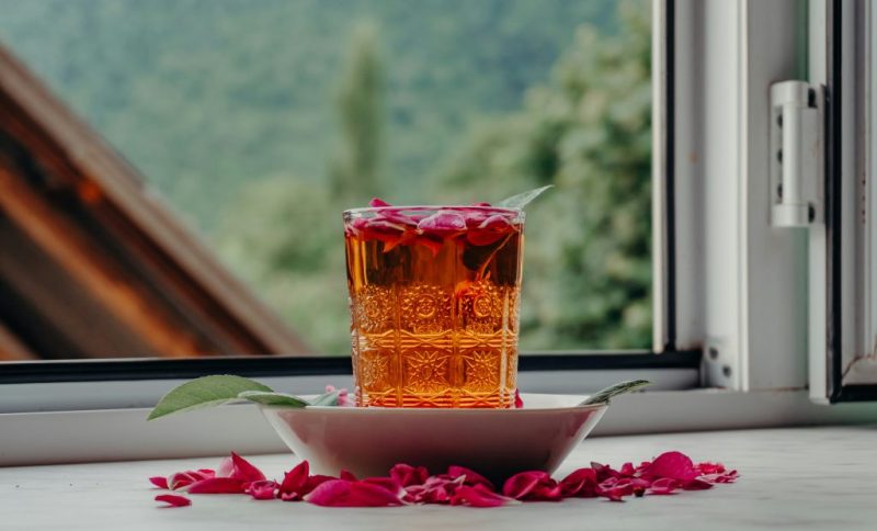 لیوان چایی پشت پنجره رو به طبیعت