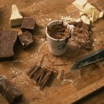 نوشیدنی موکا در حال تهیه روی میز کار با شکلات