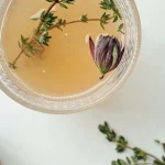 دمنوش آویشن با شاخه آویشن تازه در فنجان شیشه‌ای