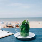 برگ های نعناع در لیوان با نمای ساحل برای دمنوش خنک