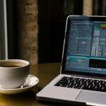 قهوه آمریکانو کنار لپ تاپ پشت پنجره صبح