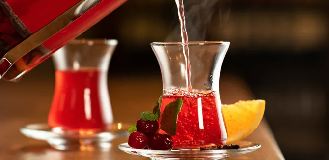 دو استکان چای آلبالو در حال پر کردن