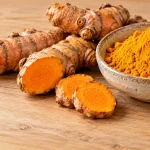 ریزوم تازه زردچوبه با برش نارنجی در کنار پودر زردچوبه