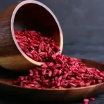 دانه های زرشک در کاسه و پیمانه برای تهیه دمنوش و غذا