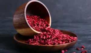 دانه های زرشک در کاسه و پیمانه برای تهیه دمنوش و غذا