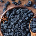 دانه های مویز در ظرف چوبی همراه با یک عدد بادیان ستاره ای